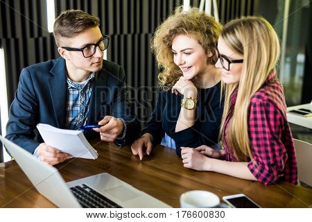 Group Of Friends Working On Their Small Business Modern Office. Man Show On His Notice On Notebook