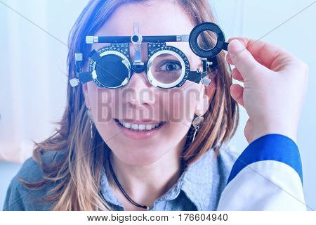 Girl woman in messbrille glasses in ophthalmology clinic. Ophthalmic glasses for diopter detection.