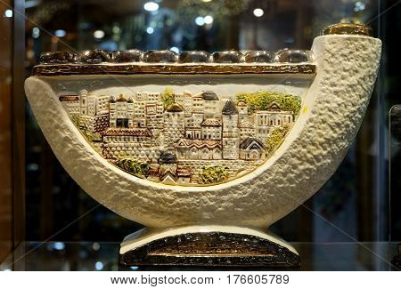 TIBERIAS ISRAEL - FEBRUARY 26 2017: Chanukah candlestick in the window of the souvenir shop. Design of Chanukiah contains a shofar and a stylized drawing of the houses of Jerusalem