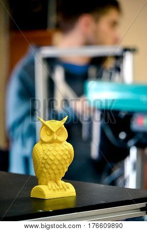 Object printed on a 3d printer close-up in the workshop. Automatic three dimensional 3d printer performs plastic yellow colors modeling in laboratory. Progressive modern additive technology
