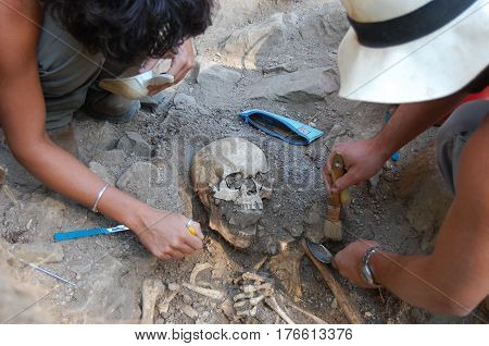 Archaeologist excavating an ancient burial . .