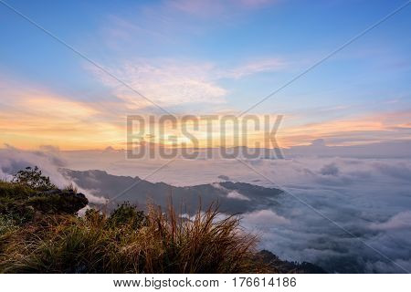 Beautiful landscape nature sunrise on peak mountain with sun cloud fog and bright colors of sky in winter at Phu Chi Fa Forest Park is a famous tourist attraction of Chiang Rai Province Thailand
