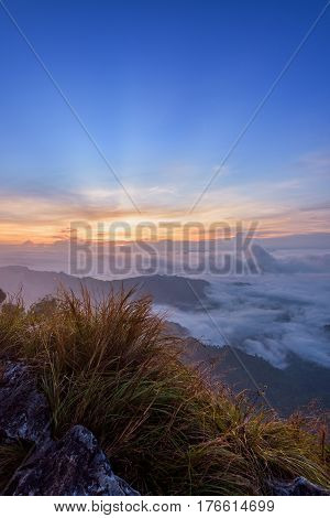 Beautiful landscape nature sunrise on peak mountain with sun cloud fog and bright colors of sky in winter at Phu Chi Fa Forest Park is a famous tourist attraction of Chiang Rai Province Thailand