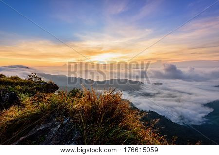 Beautiful landscape nature sunrise on peak mountain with sun cloud fog and bright colors of sky in winter at Phu Chi Fa Forest Park is a famous tourist attraction of Chiang Rai Province Thailand