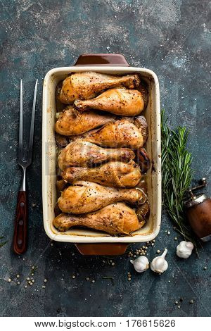 Grilled fried roast chicken legs drumsticks on dark background meat with ingredients for cooking top view