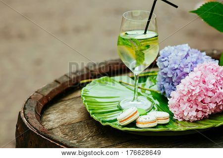 Lemonade in the glass and lemons with mint on the table outdoors