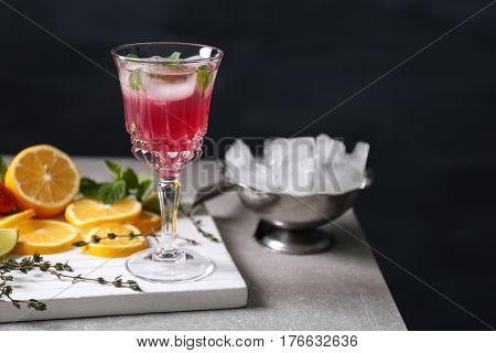 Glass of delicious wine spritzer on black background