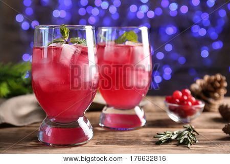 Glasses of delicious wine spritzer on blurred lights background