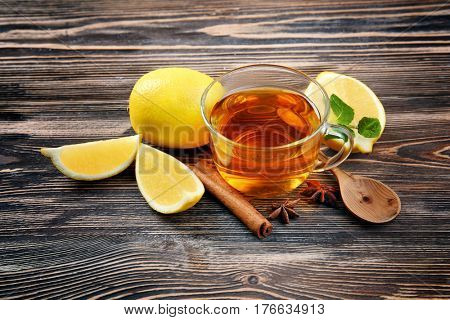 Hot drink with honey and lemon for cough remedy on wooden table