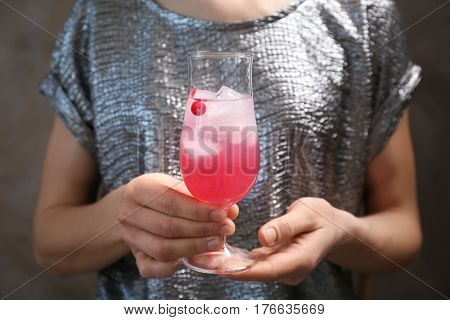 Woman holding glass of delicious wine spritzer