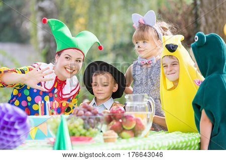 Femaly party entertainer and children wearing costumes during garden party