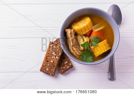 Puchero Soup With Corn And Parsley On Wooden Table