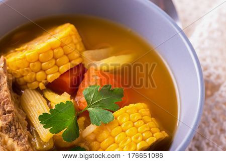Puchero Soup With Corn And Parsley On Wooden Table