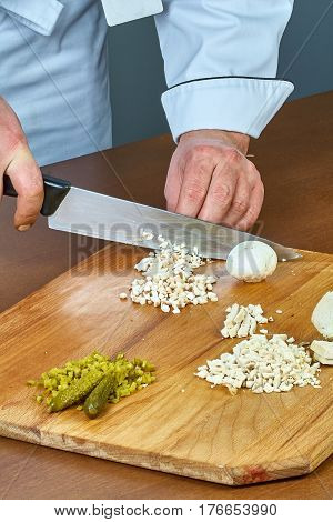 Cook cuts champignons for making a jelly chicken collection of culinary recipes