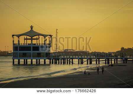 Labuan,Malaysia-Mac 15,2017:View of Manja Rasa floating restaurant during sunset with silhouette of people in the beach in Labuan island,Malaysia.