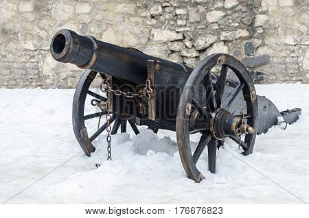 Old black gun in ancient castle of Mukacheve Ukraine winter time
