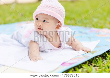 Cute Asian Baby Lie Prone On Ground At Park