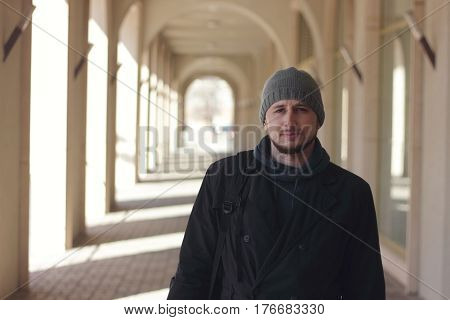 Portrait of a young man outdoors, cold sunny winter day, telephoto