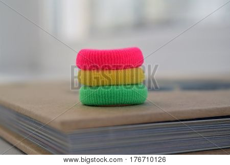 Colorful scrunchies (green yellow red) on book background