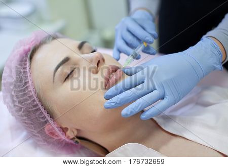 Woman gets injection in her face. Beauty woman giving injections. Young woman gets beauty facial injections in the cosmetology salon. Face aging injection. Aesthetic Medicine, Cosmetology