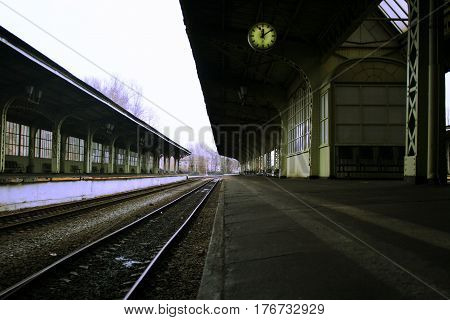 Platform clock and benches without people and no train