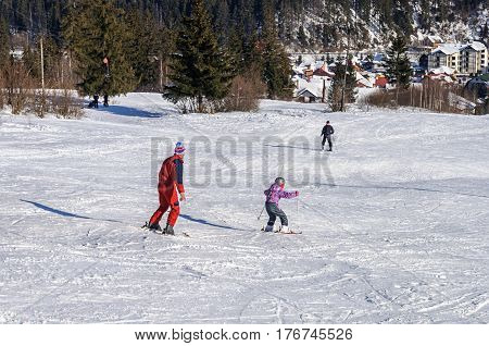 Slavsko, Ukraine - January 30, 2017: Little boy with his father skiing on a mountain slope in Carpathians