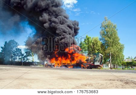 truck in fire with black smoke on the road