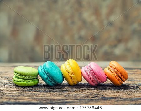 Colorful macarons on vintage pastel background. Macaron or Macaroon is sweet meringue-based confection.