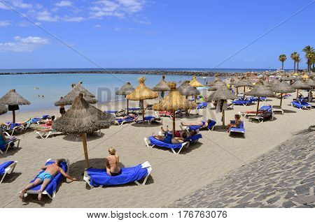 Playa De Las Americas beach Tenerife Canary Islands Spain Europe - June 18 2016: Tourists on the beach enjoying the sun