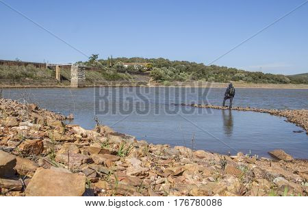 Man overlooking the Roman Dam of Cornalvo. This dam was declared National Monument on Dec 13th 1912 and it is still in use nowadays