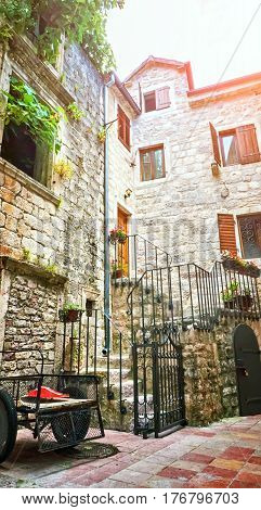 Kotor narrow small streets of historical old town. House drying linen bright sun blind old stone. Authentic structures. No body tourists.