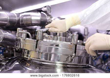 A Man Opens A Chemical Reactor. Rector Of The Pharmaceutical Industry. The Man Closes The Reactor. P