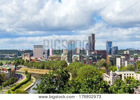 Panorama of Vilnius from top of mountain of Gediminas Tower. Red rooftops of old town & modern business building of glass and concrete. River Vilia parts of historic and business districts. Lithuania