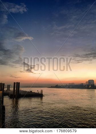 Dramatic and colorful sunset reflected in the water of the river Scheld in Antwerp Belgium Europe