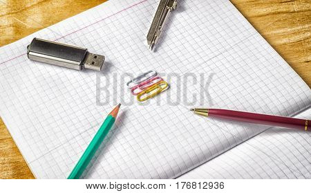 Office supplies on paper necessary for office flash drive for storing information notebook for writing compasses for drawers pencil and pen for writing paper clips for stapling documents