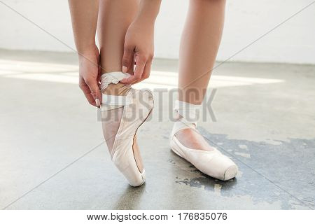 Ballerina's feet in pointe shoes over a grey background