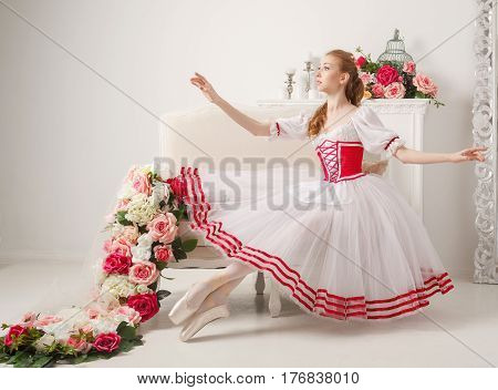 Cute ballerina in stage costume next to bouquets of spring flowers. Retro dress.