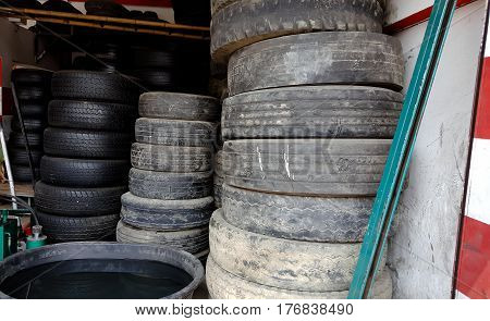Column stack of old used car tires in secondary car parts shop garage