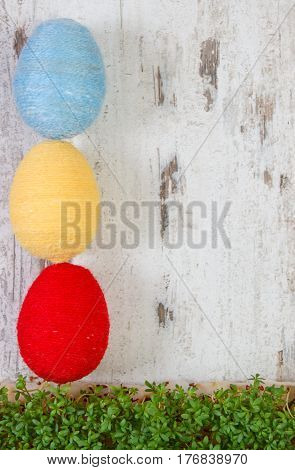 Easter Eggs Wrapped Woolen String And Green Cress On Wooden Background, Copy Space For Text, Decorat