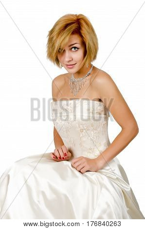 Happy girl in a white evening dress and necklace. Bare shoulders. Butch. Isolated on white background