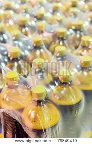 Packaging plastic bottles at the brewery. Packed shrink packaging film.