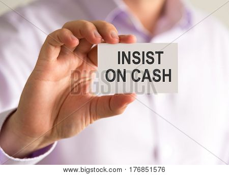 Businessman Holding A Card With Insist On Cash Message