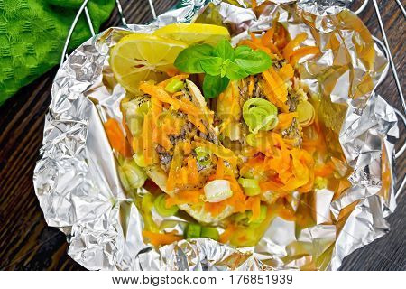 Pike With Carrots And Basil In Foil On Board Top