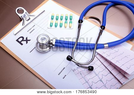 RX prescription, Red heart, asorted pils and a stethoscope on white background.