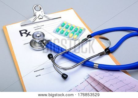RX prescription, Red heart, asorted pils and a stethoscope on white background.