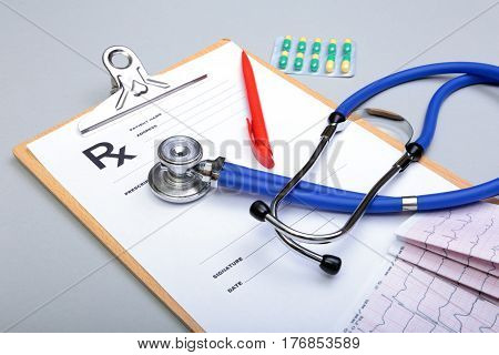 RX prescription, Red heart, asorted pils and a stethoscope on white background.