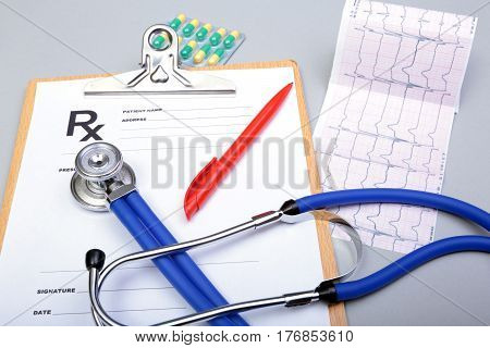 RX prescription, Red heart, asorted pils and a stethoscope on white background.