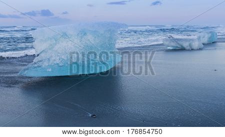 Ice cube on black volcano sand beach Iceland natural winter season landscape