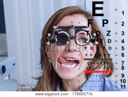 Girl woman in messbrille glasses in ophthalmology clinic. Ophthalmic glasses for diopter detection.