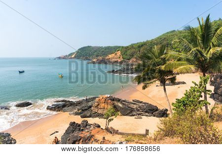 Paradise beach in Gokarna India. Beautiful deserted landscape with clean sand and wave. View from the sea to the shore.